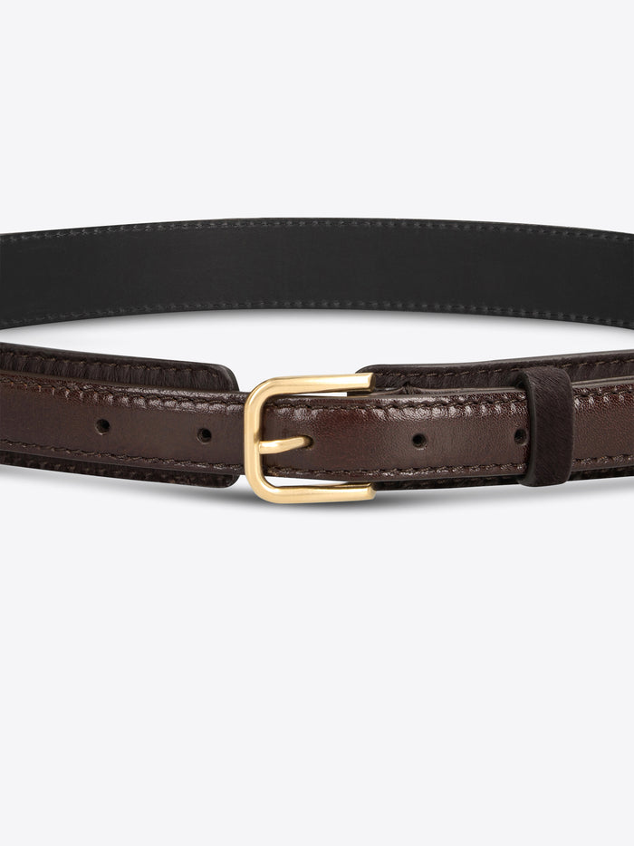 Close-up of a dark brown textured belt with smooth leather trim and a gold-toned buckle on a light gray background.

