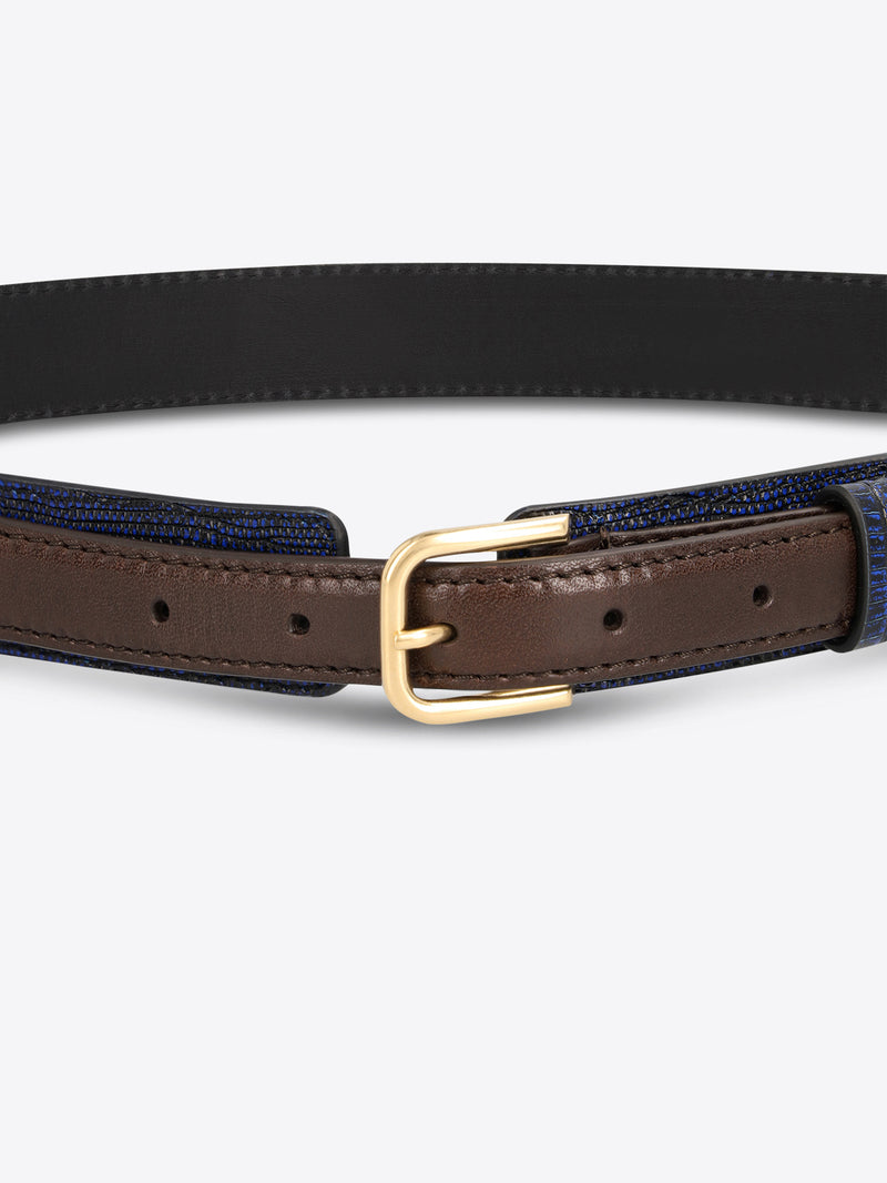 Close-up of a dark blue textured belt with brown leather trim and a gold-toned buckle on a light gray background.
