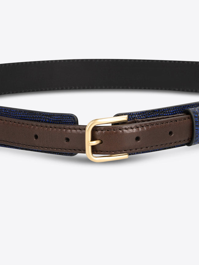 Close-up of a dark blue textured belt with brown leather trim and a gold-toned buckle on a light gray background.

