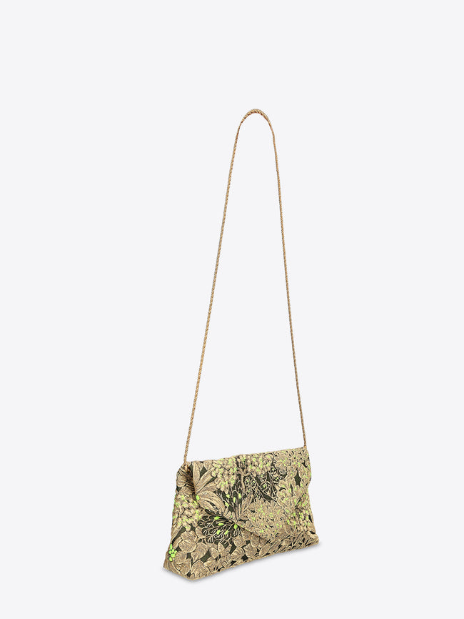 Fold-over clutch bag in black-and-gold floral jacquard with bright green accents on a light gray background.