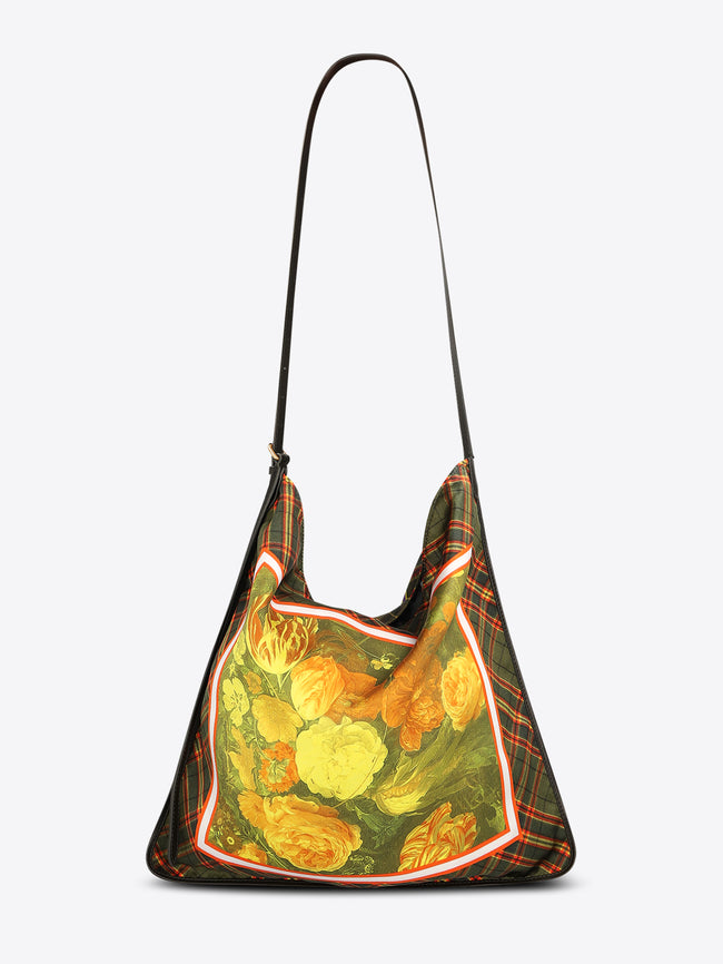 Triangular shoulder bag with a long black strap, green plaid panels, and a yellow-orange floral center framed with red and white trim on a light gray background.