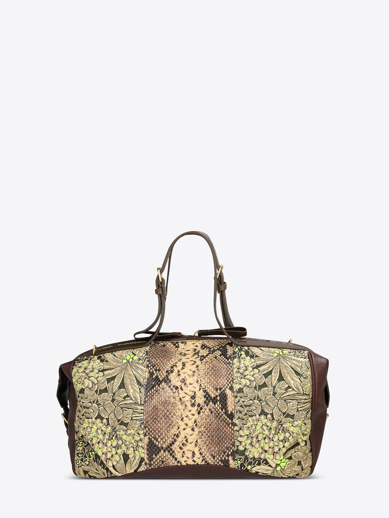 Structured duffle bag with dark brown leather trim, a tan snakeskin-effect center panel, and black-and-gold floral jacquard sides with green accents on a light gray background.