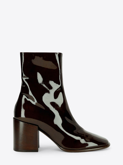 Dark olive patent leather ankle boot with a rounded square toe and chunky block heel on a light gray background.