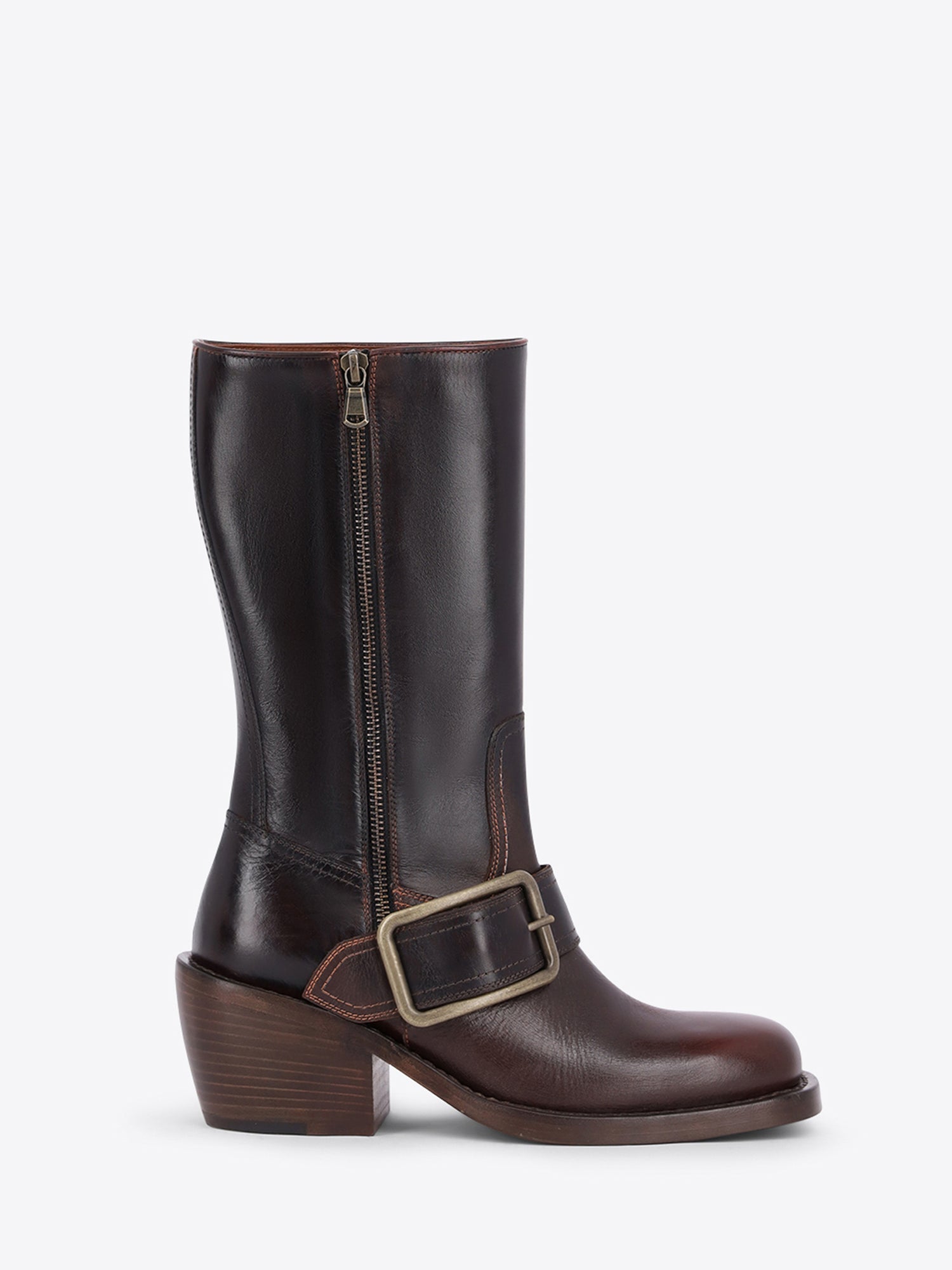 A dark brown leather mid-calf boot with a side zipper, a decorative buckle strap across the instep, and a stacked block heel, shown against a light gray background.