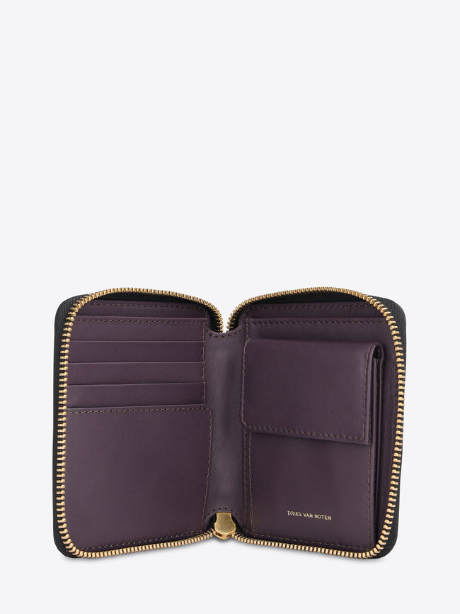 A small zip-around wallet featuring a dark purple leather interior, gold-tone zippers, and multiple card slots, shown open against a light gray background.