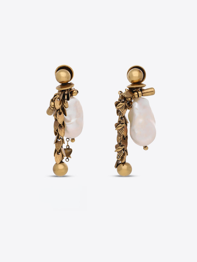 A pair of gold-toned statement dangle earrings featuring irregular white baroque pearls and textured gold leaf-like details, shown against a light gray background.