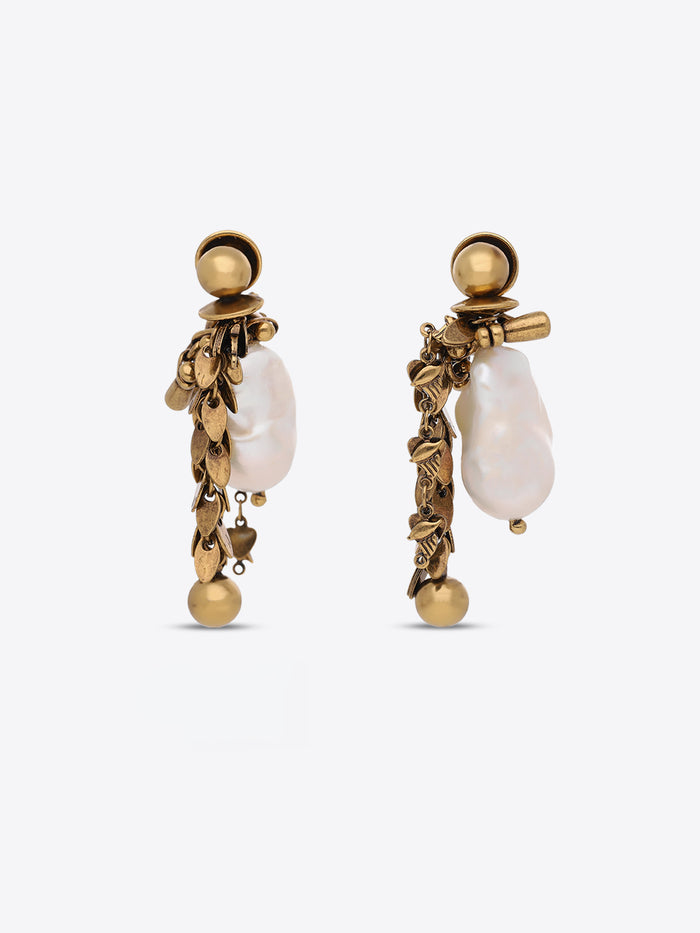 A pair of gold-toned statement dangle earrings featuring irregular white baroque pearls and textured gold leaf-like details, shown against a light gray background.