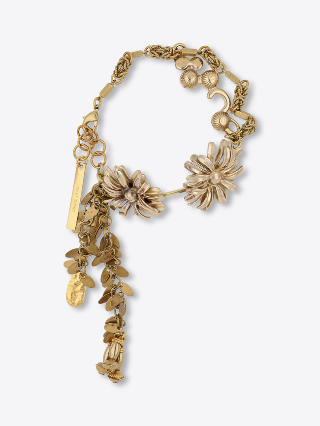 Old brass charm bracelet with two sculpted flower motifs, textured chain links, and dangling leaf and teardrop charms on a light gray background.