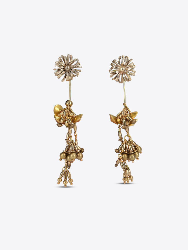 A pair of gold-toned dangle earrings with floral stud tops, small winged fairy motifs, and dangling bead clusters, shown on a light gray background.