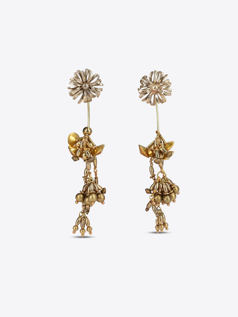 A pair of gold-toned dangle earrings with floral stud tops, small winged fairy motifs, and dangling bead clusters, shown on a light gray background.
