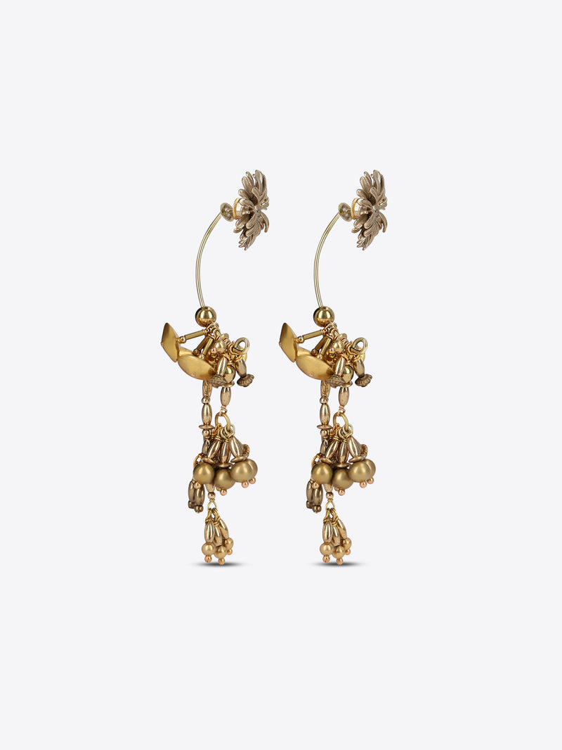 A pair of gold-toned dangle earrings with floral stud tops, small winged fairy motifs, and dangling bead clusters, shown on a light gray background.