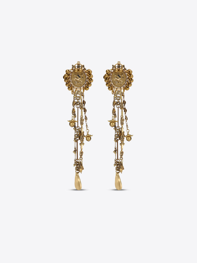 Pair of old brass drop earrings with oval medallions, cascading chains, floral charms, and teardrop pendants on a light gray background.