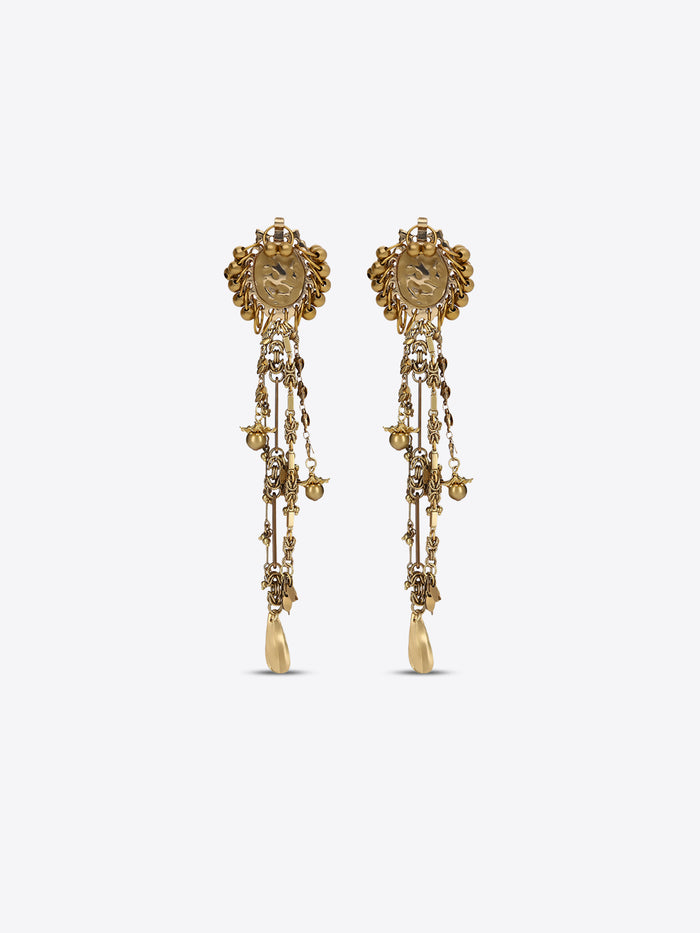 Pair of old brass drop earrings with oval medallions, cascading chains, floral charms, and teardrop pendants on a light gray background.
