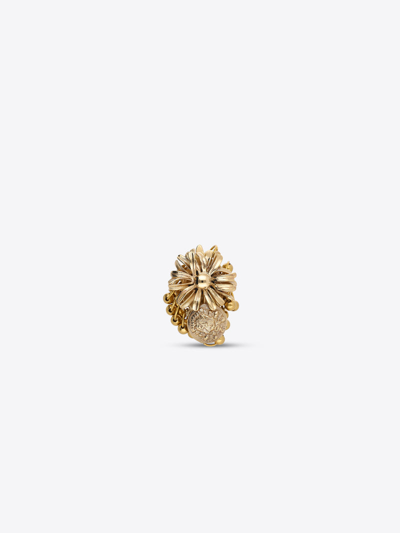 Gold-toned flower ring with layered petals and a dangling embossed medallion charm on a light gray background.