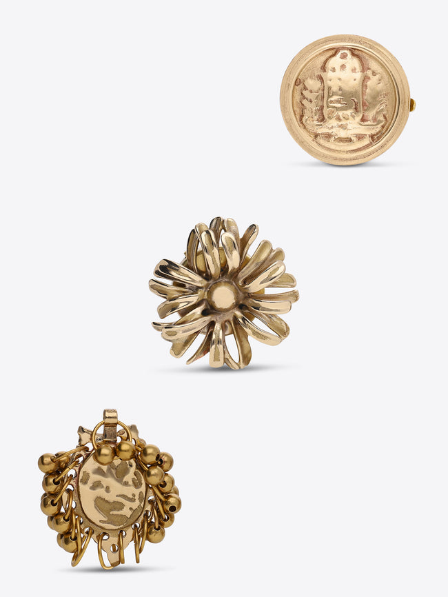 Three-piece gold-toned button cover set featuring a round medallion, a flower-shaped design, and a grape-cluster design with a central oval charm, shown on a light gray background.