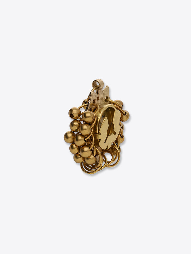 Back view of a gold-toned grape-cluster button cover, showing its fastening mechanism on a light gray background.