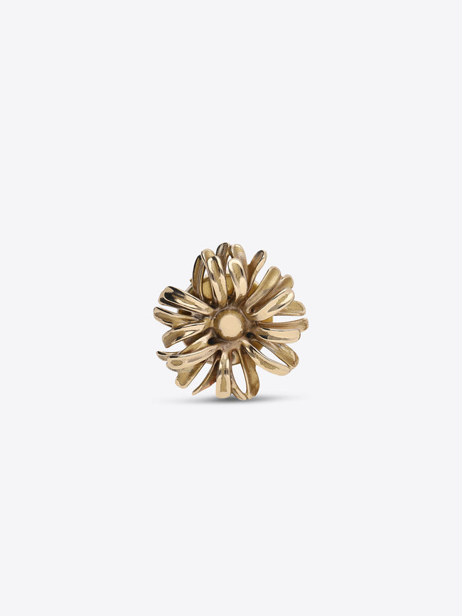 Front view of a gold-toned flower-shaped button cover with layered petals on a light gray background.