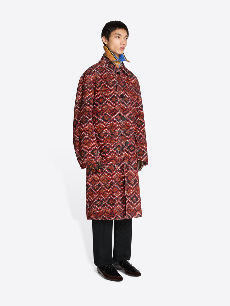 Person wearing a patterned coat on a white background