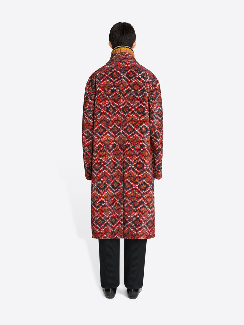 Back view of a person wearing a patterned coat on a white background