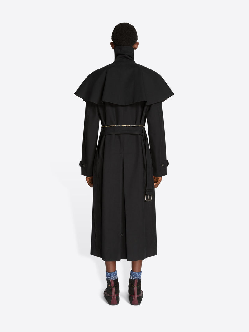Back view of a person wearing a black long coat on a white background