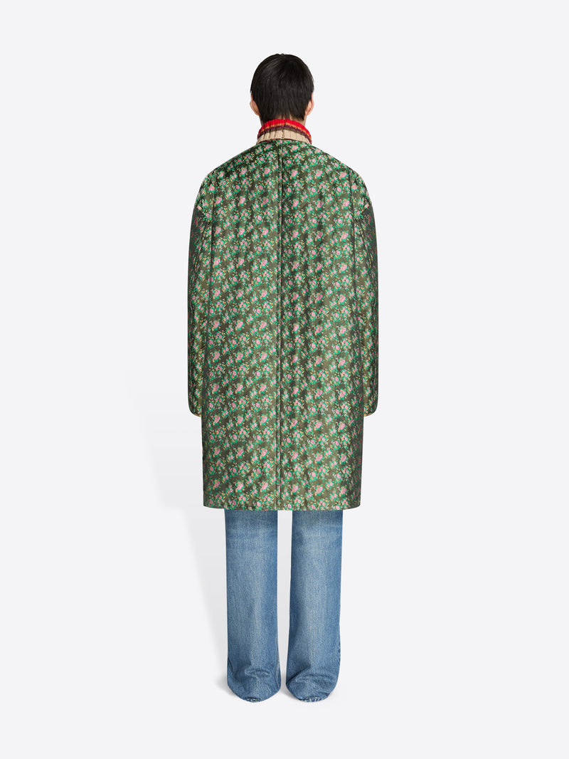 Person wearing a green patterned coat on a white background