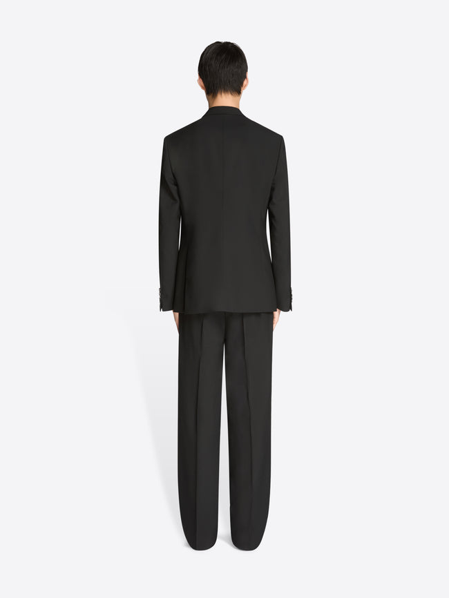 Back view of a person wearing a black suit on a white background