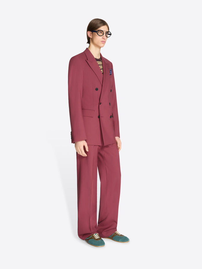 Person wearing a burgundy suit with a white background