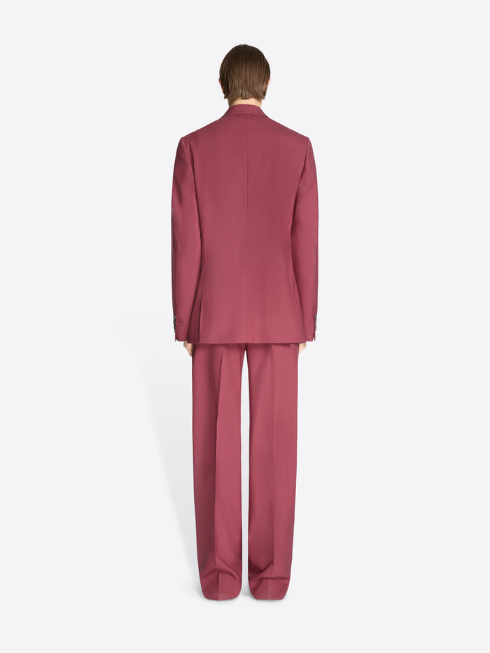 Person wearing a burgundy suit on a white background