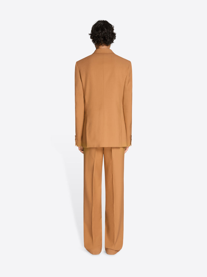 Back view of a person wearing an orange suit on a white background