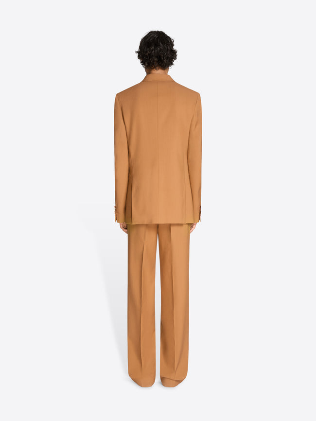 Back view of a person wearing an orange suit on a white background