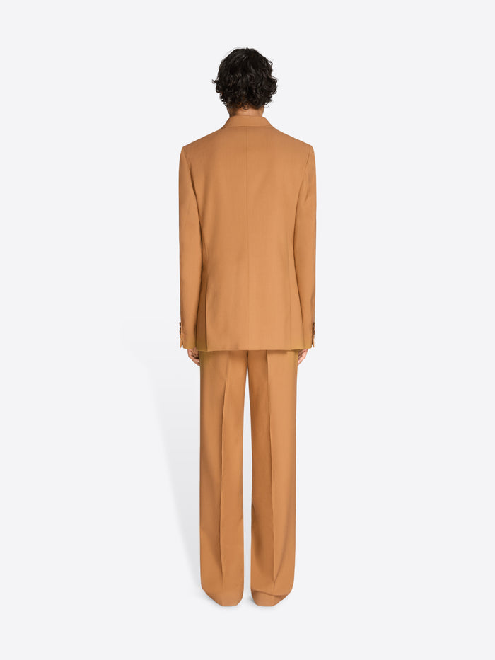 Back view of a person wearing an orange suit on a white background