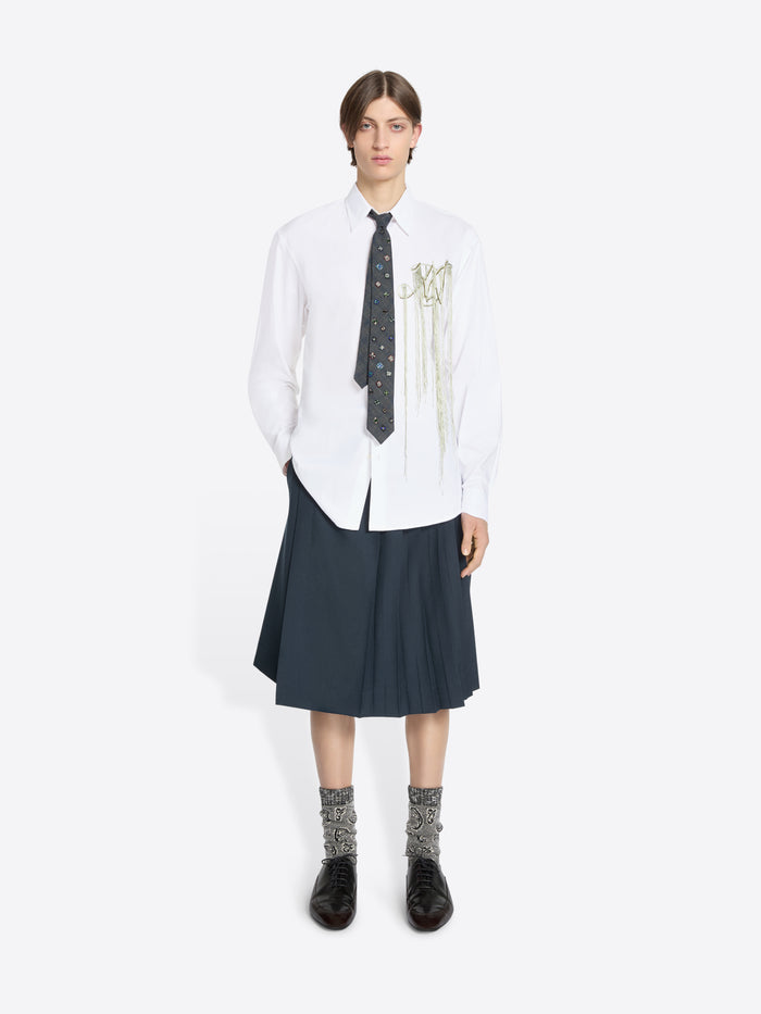 Person wearing a white shirt with a tie and dark skirt on a white background