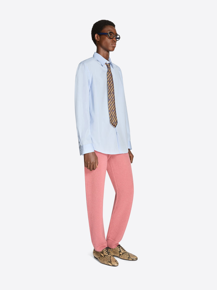 Person wearing a light blue shirt, pink pants, and patterned tie