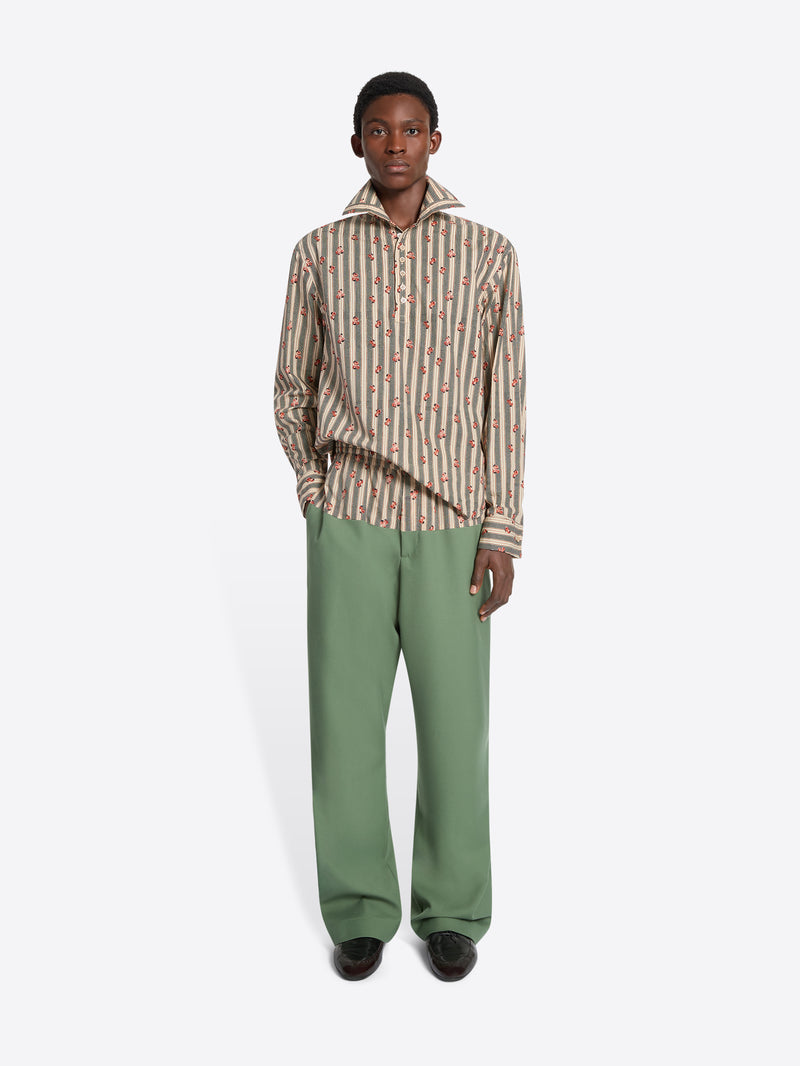 Person wearing a striped shirt and green pants on a white background