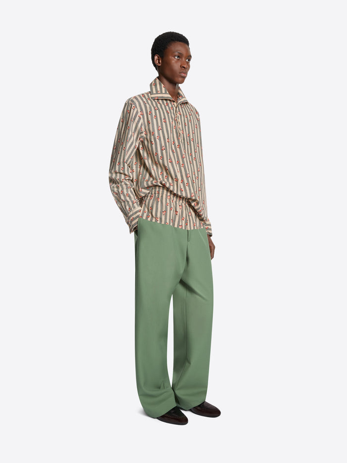 Person wearing a striped shirt and green pants on a white background