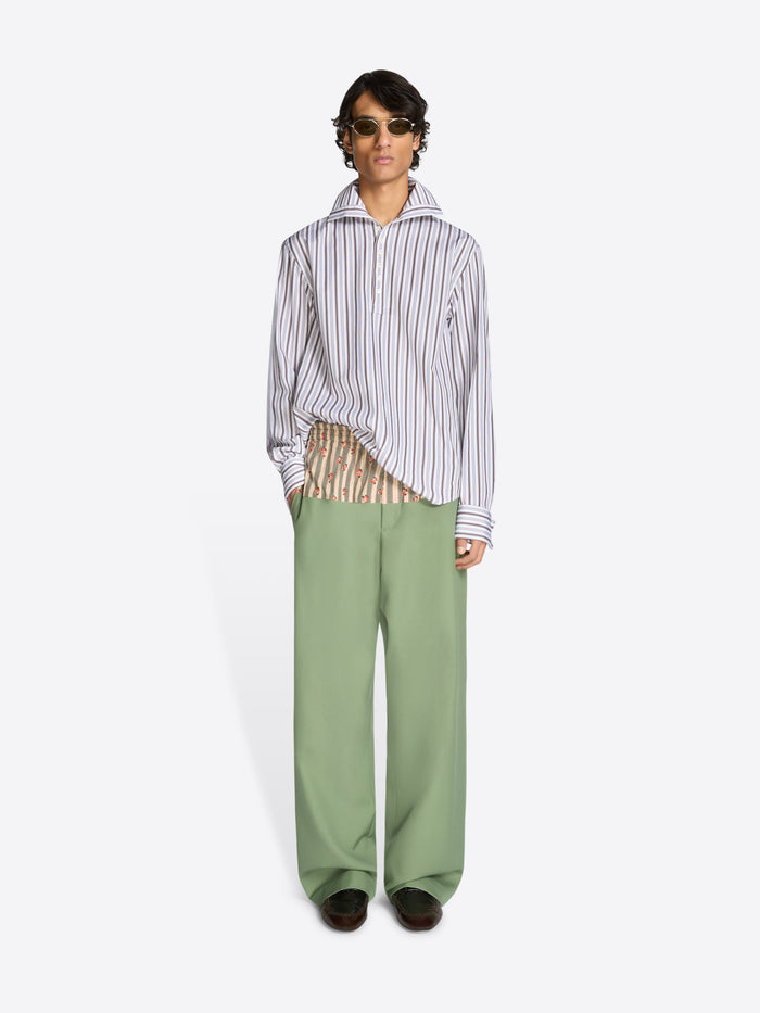 Person wearing a striped shirt and green pants on a white background