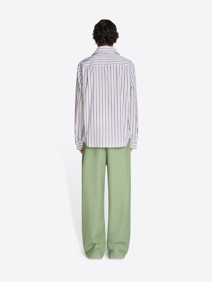 Back view of a person wearing a striped shirt and green pants on a white background