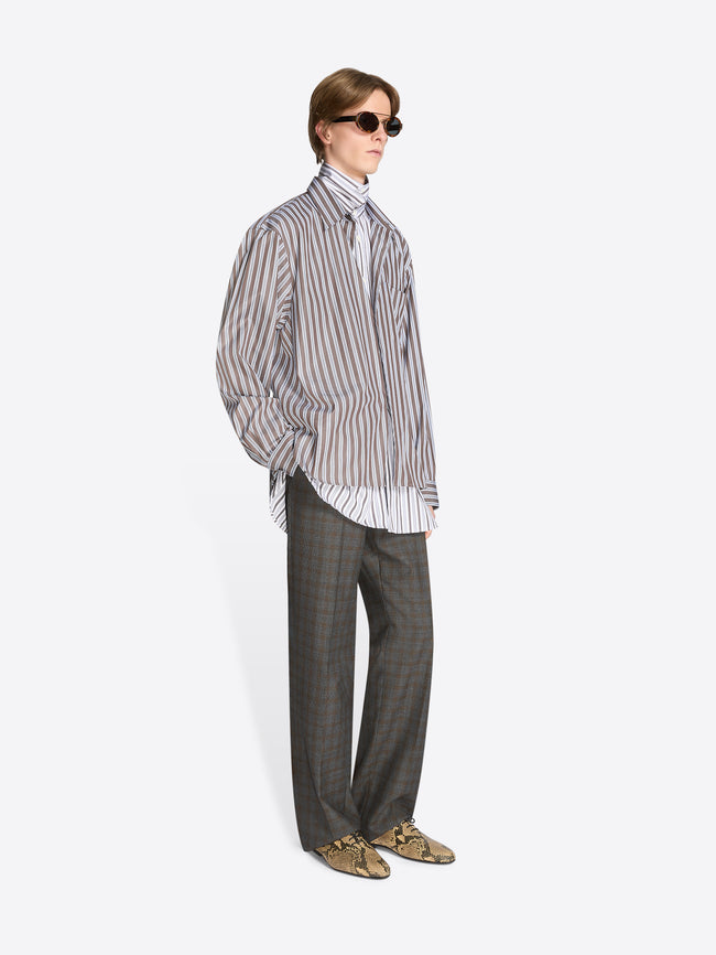 Person wearing a striped shirt and checkered pants on a white background