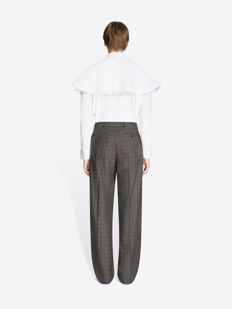 Back view of a person wearing a white shirt and gray checkered pants on a white background