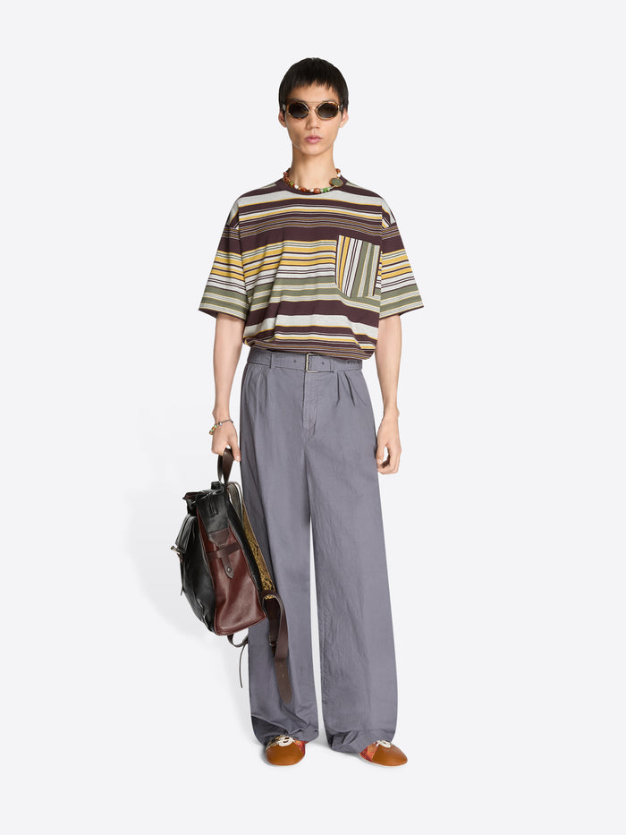 Person wearing a striped t-shirt and gray pants holding a brown backpack on a white background