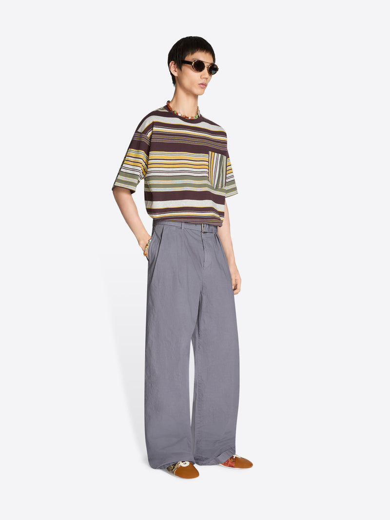 Person wearing a striped t-shirt and pleated gray pants on a white background