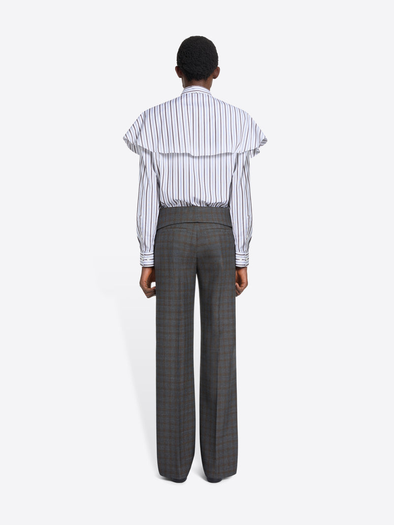 Person wearing a striped shirt and checkered pants on a white background