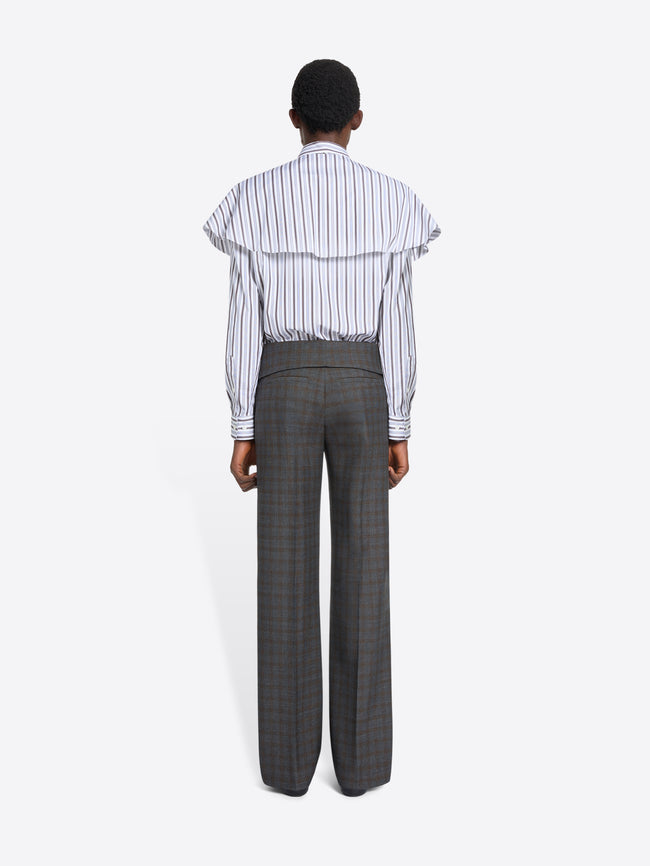 Person wearing a striped shirt and checkered pants on a white background