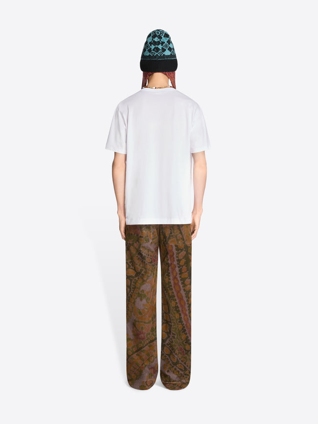 Back view of a person wearing a white t-shirt patterned pants, a hat on a white background