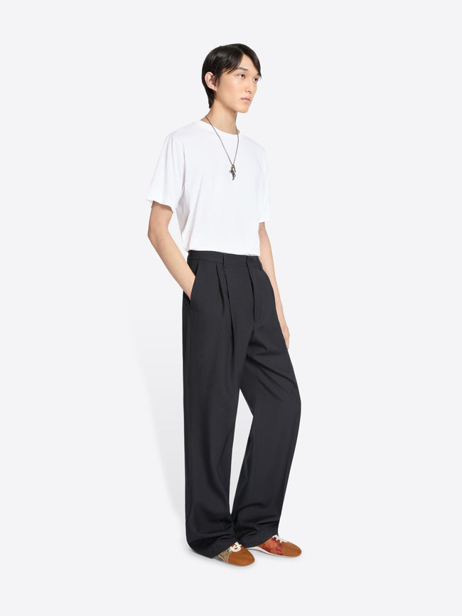 Person wearing a white t-shirt and black wide-leg pants on a white background