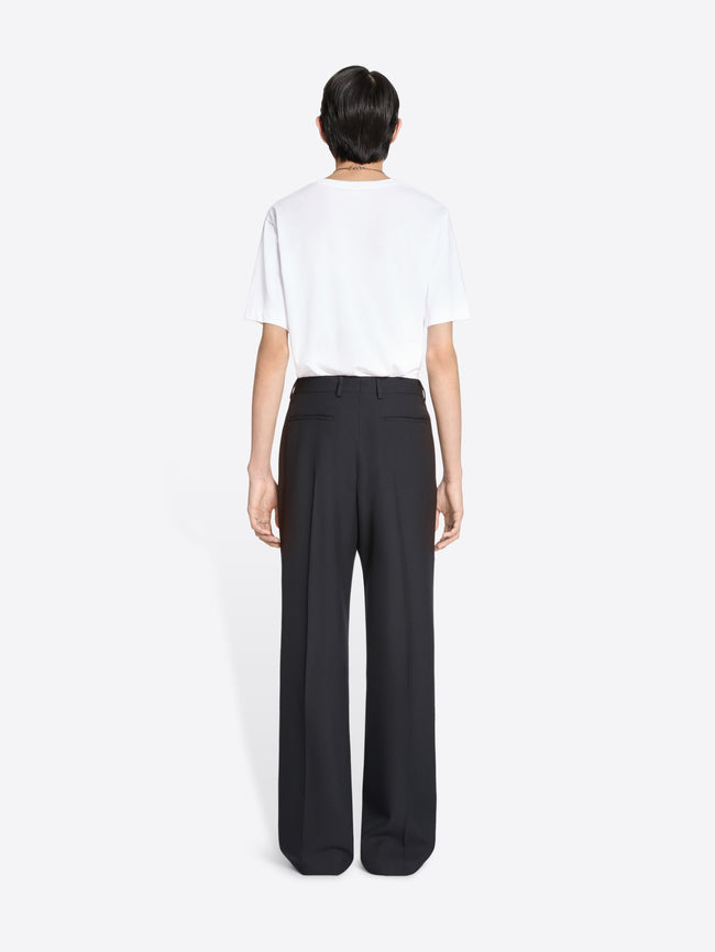 Person wearing a white t-shirt and black pants on a white background