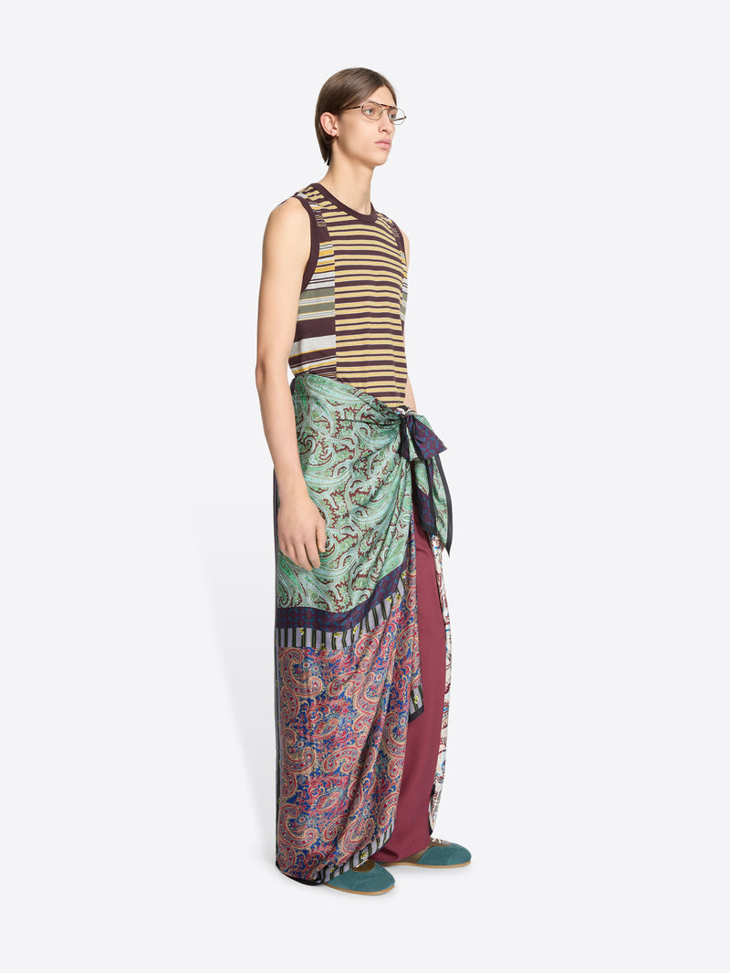 Person wearing a striped tank top and patterned pareo on a white background