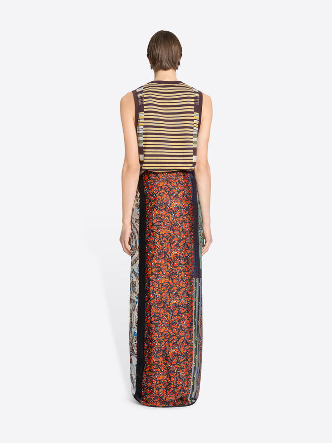 Back view of a person wearing a striped tank top and patterned pareo on a white background