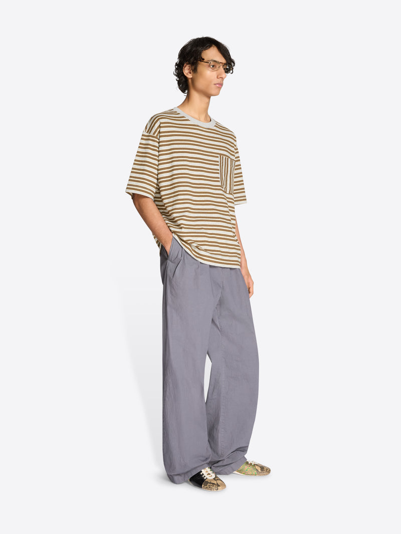 Person wearing a striped t-shirt and gray pants on a white background