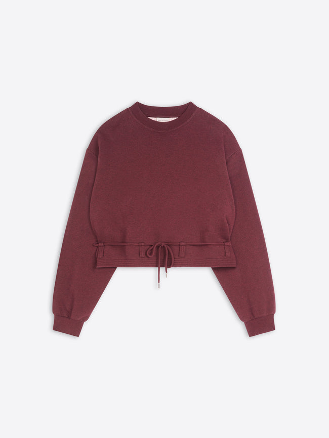Burgundy cropped crew-neck sweatshirt with long sleeves, ribbed cuffs, and an adjustable drawstring hem, displayed against a light gray background.
